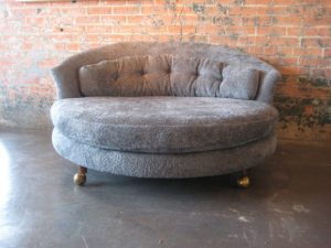 oversized living room chair large round chaise lounge with tufted back and wooden leg with wheel placed on concrete floor combined brick wall x